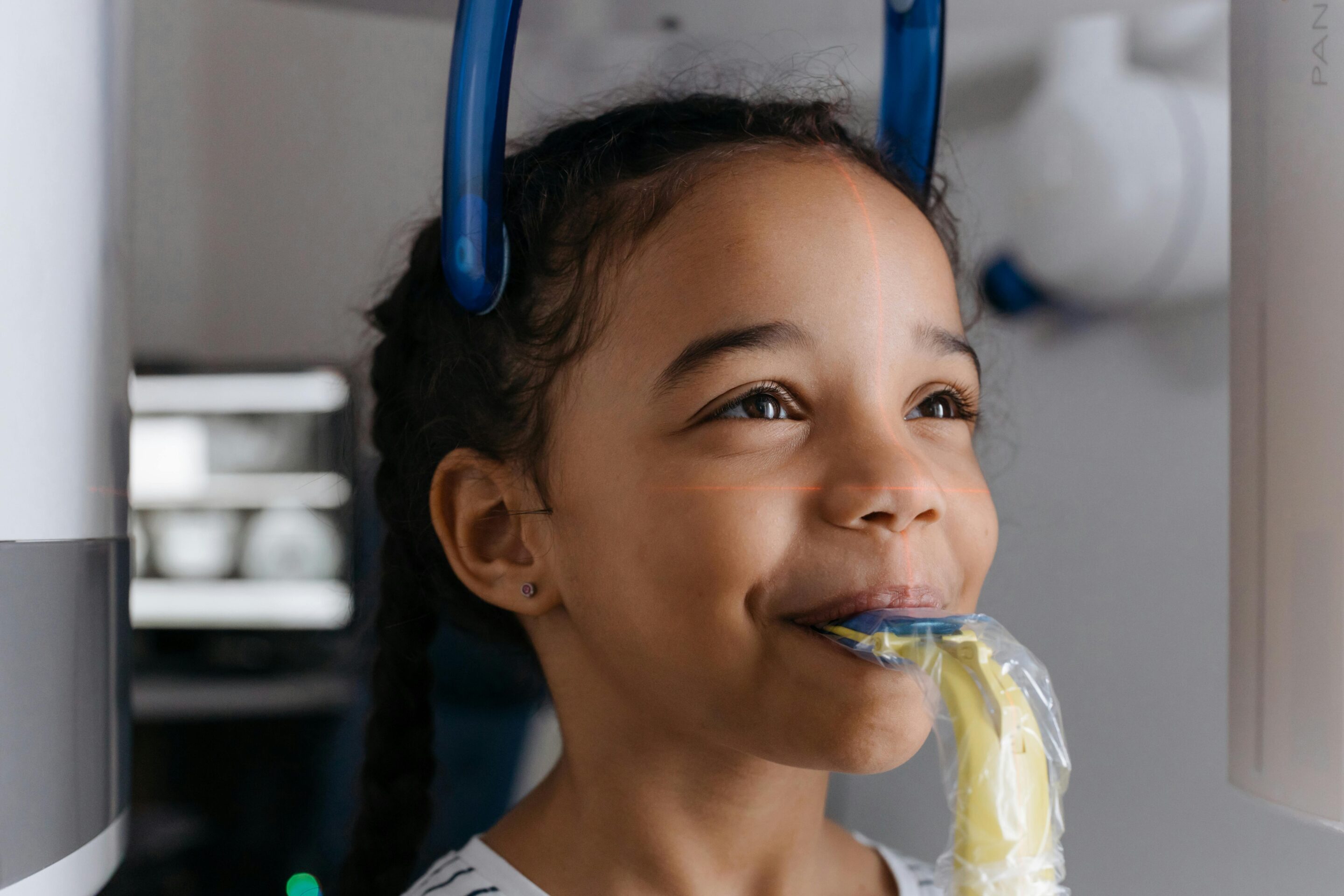 Child smiling during a dental x-ray