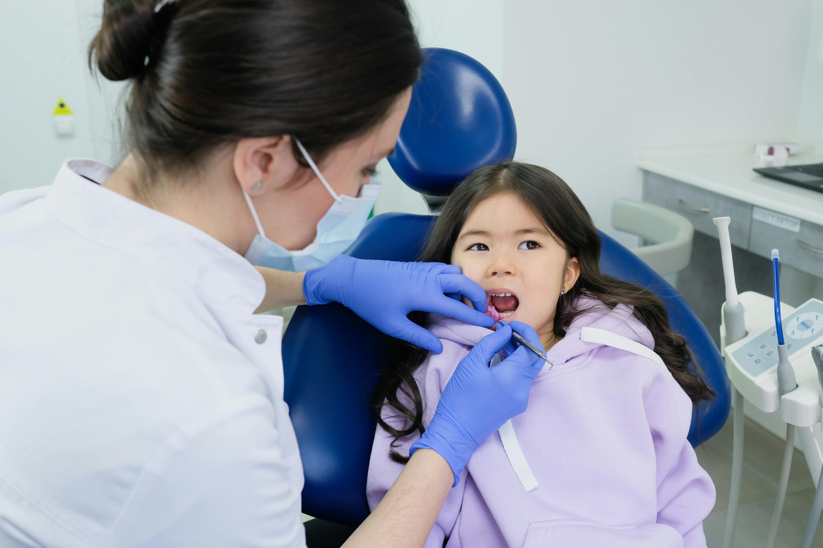 Pediatric dentist checking a child's teeth