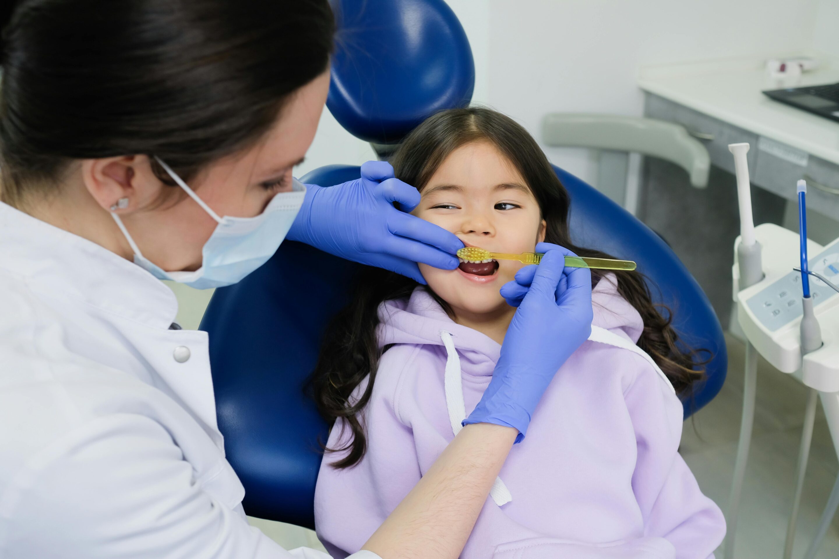 Pediatric dentist brushing a child's teeth