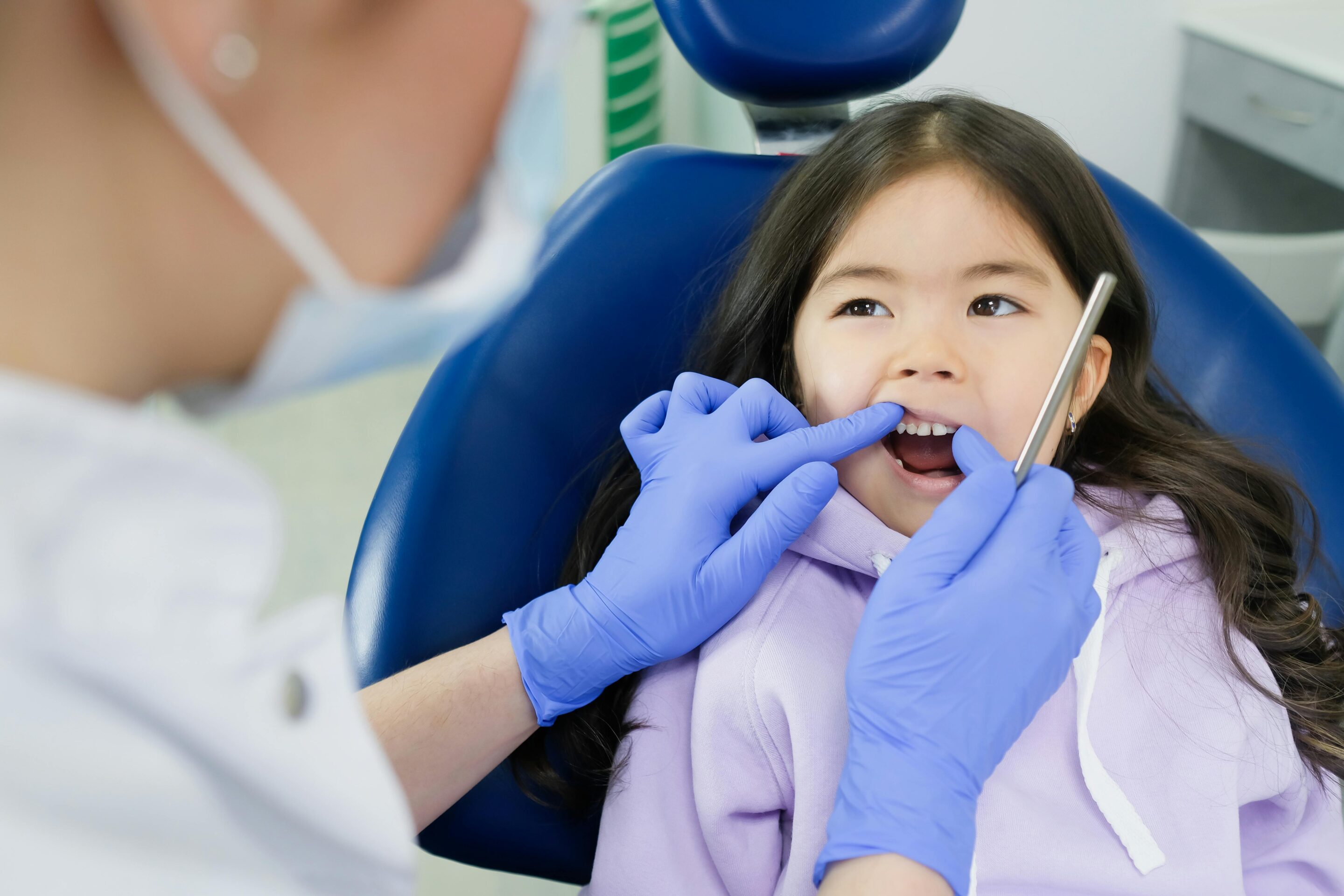 Dentist examining a young child in clinic